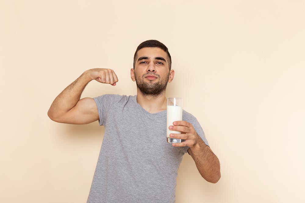 front view young male in grey t shirt holding glass of milk on t