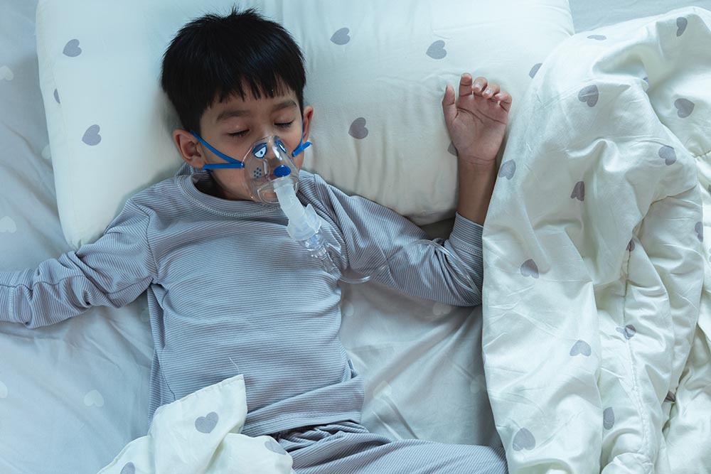 Sick Asian Boy Respiratory syncytial virus wears pediatric venti